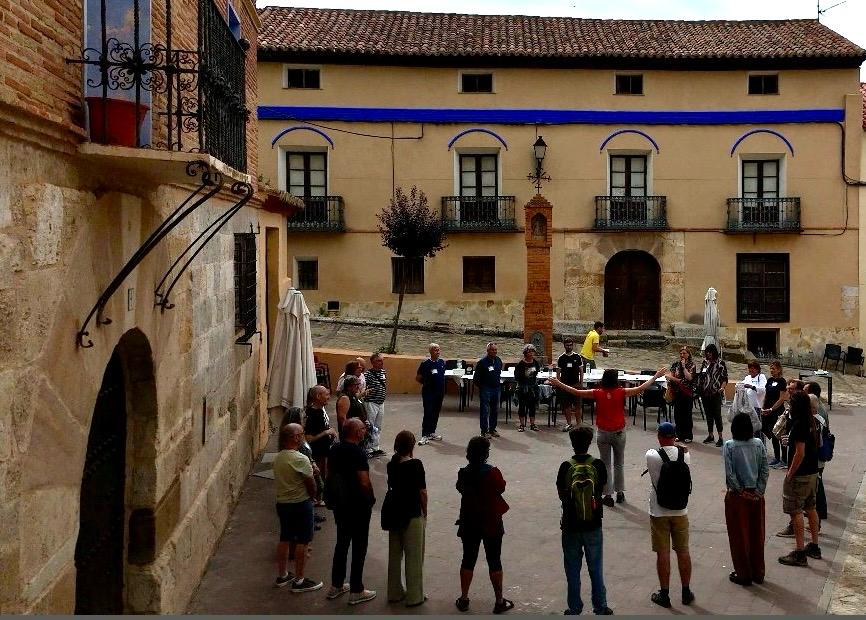 Dinámica de bienvenida 1 Los asistentes forman un gran círculo en la plaza y una persona en medio está explicando algo con los brazos abiertos
